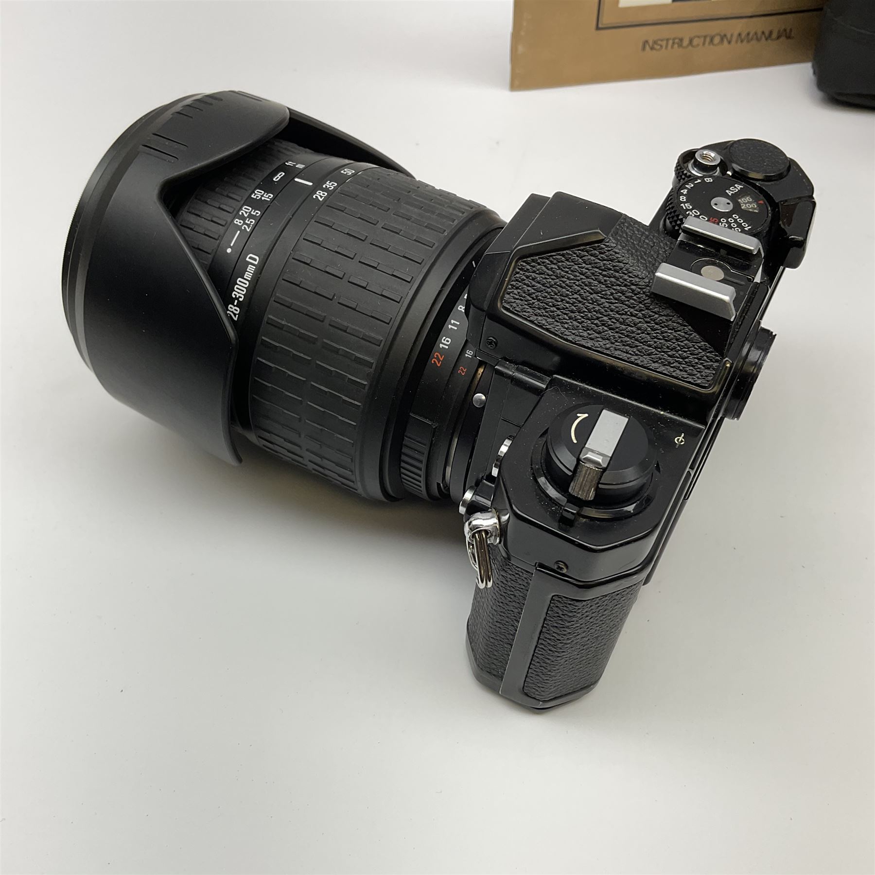 Nikon FM 35mm SLR camera body, Sigma 28-300mm 1:3.5-6.3 lens, Cosina 100mm 1:3.5 macro lens, two macro adaptors, instruction manual, Nikon 'Lite-Touch zoom' 35mm camera, and three relating carrying cases