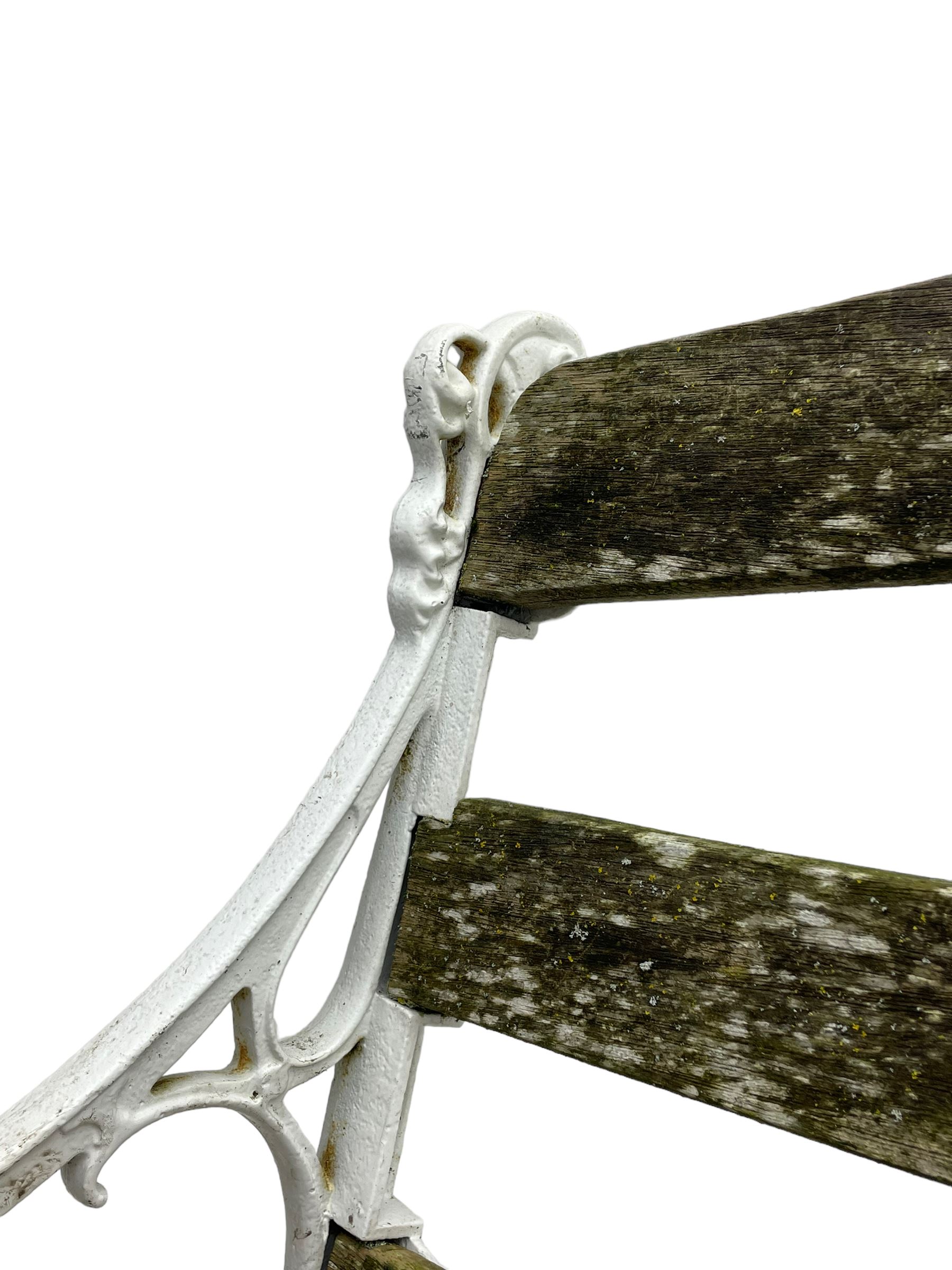 Late 19th century white painted cast iron and wood slatted garden bench, the bench ends in the form of S-scroll mythical beasts with paw feet, central cartouche surrounded by extending trailing foliage, the back slats divided by scroll cast splats, central seat support 