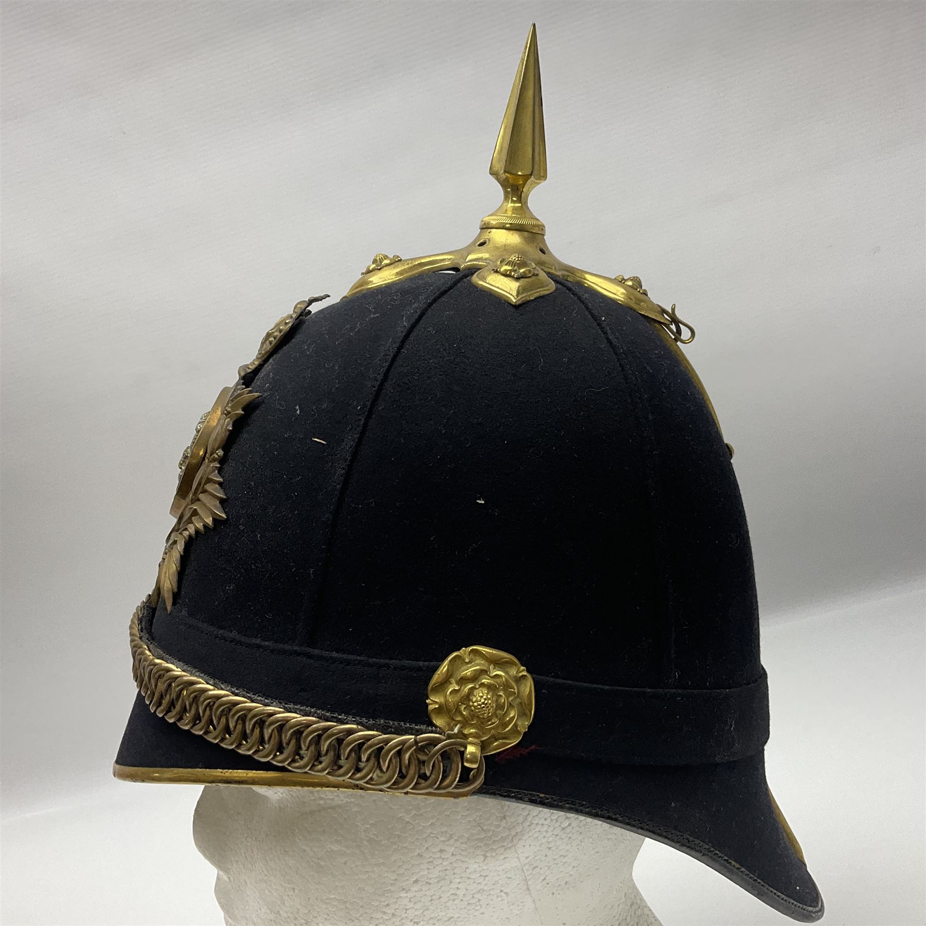 Late Victorian North Staffordshire Regiment Officer's Home Service Blue Cloth Helmet, having incorrect other ranks gilt metal Queen's crown helmet plate to the front with later leather backing, removable spike to the top on a shaped cruciform base with rosette fittings, rosette side bosses, brass trim to the front peak, and leather and velvet backed chin scales, with leather sweat band, the interior with makers stamp for Hawkes & Co 14 Piccadilly London