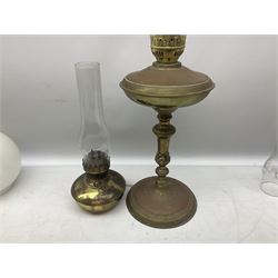 Oil lamp with a green glass reservoir, together with glass based oil lamp with glass chimney,  two brass lobed baluster form oil lamps and six similar examples