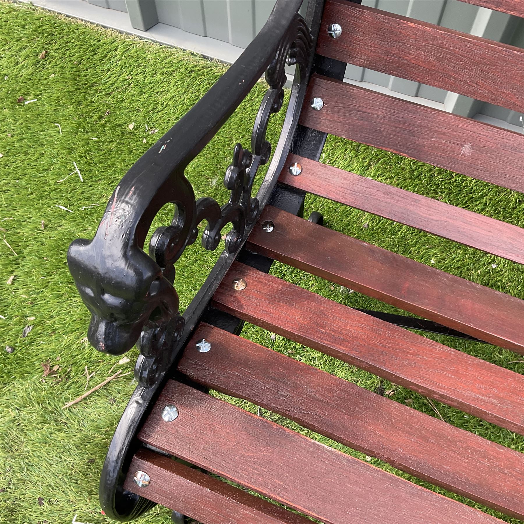 Black painted cast iron and wood slated garden bench decorated with lion heads  - THIS LOT IS TO BE COLLECTED BY APPOINTMENT FROM DUGGLEBY STORAGE, GREAT HILL, EASTFIELD, SCARBOROUGH, YO11 3TX