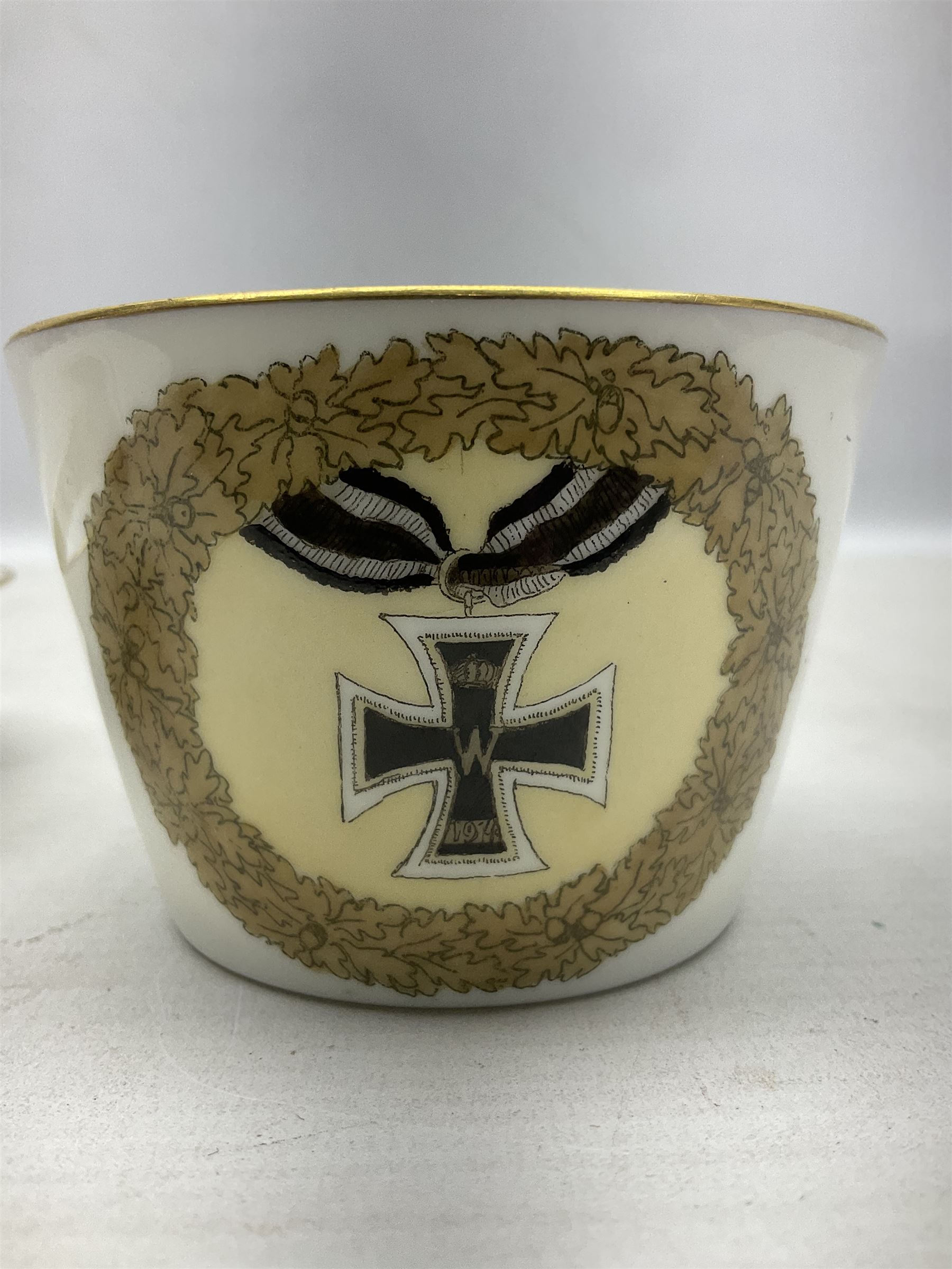 WW2 Nymphenburg cups and saucer, decorated with Imperial German Iron Cross encircled in a foliate boarder with gilt edging, with printed mark beneath 