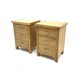 Pair light oak bedside pedestal chests, three short drawers, raised on stile supports 