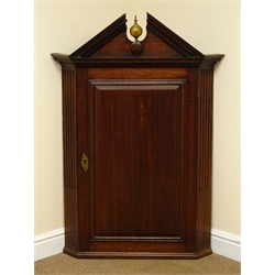  George II oak corner cupboard, architectural dentil pediment with gilt ball finial, single panel door enclosing three shaped shelves, flanked by stop fluted angles, W84cm, H121cm, D51cm  