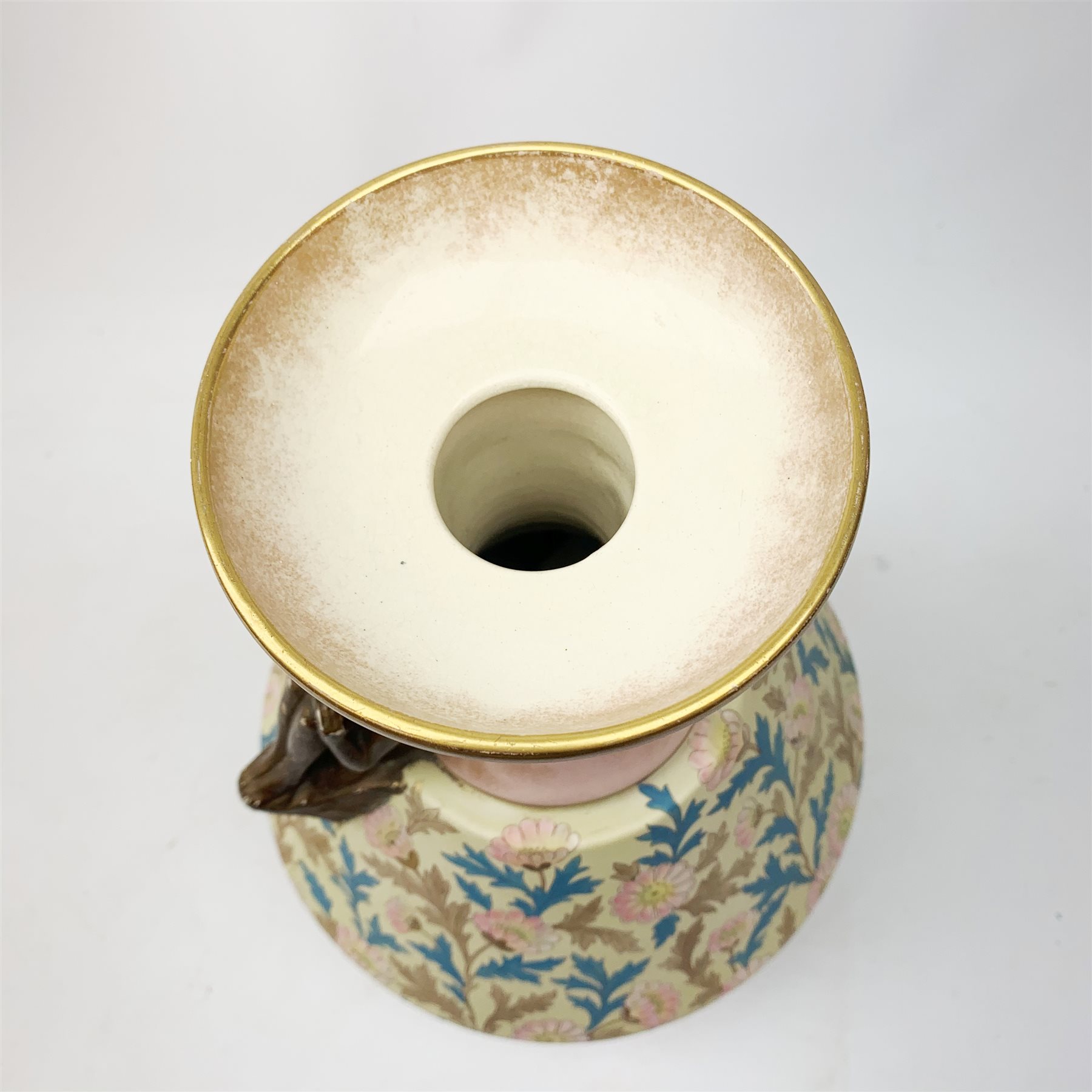 A late 19th century Aesthetic Movement Old Hall vase designed by Christopher Dresser, the flared body decorated with stylised flowering vines, leading to a tapering neck and flared rim with twin figural handles (one s/d), and raised upon a circular footed base, with printed mark beneath, H35cm. 