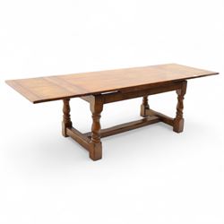 20th-century good quality solid oak extending refectory table, planked, constructed rectangular top with two extending leaves on the underside above a plain frieze raised on four turned baluster supports united by stretchers on block feet, 260cm extended