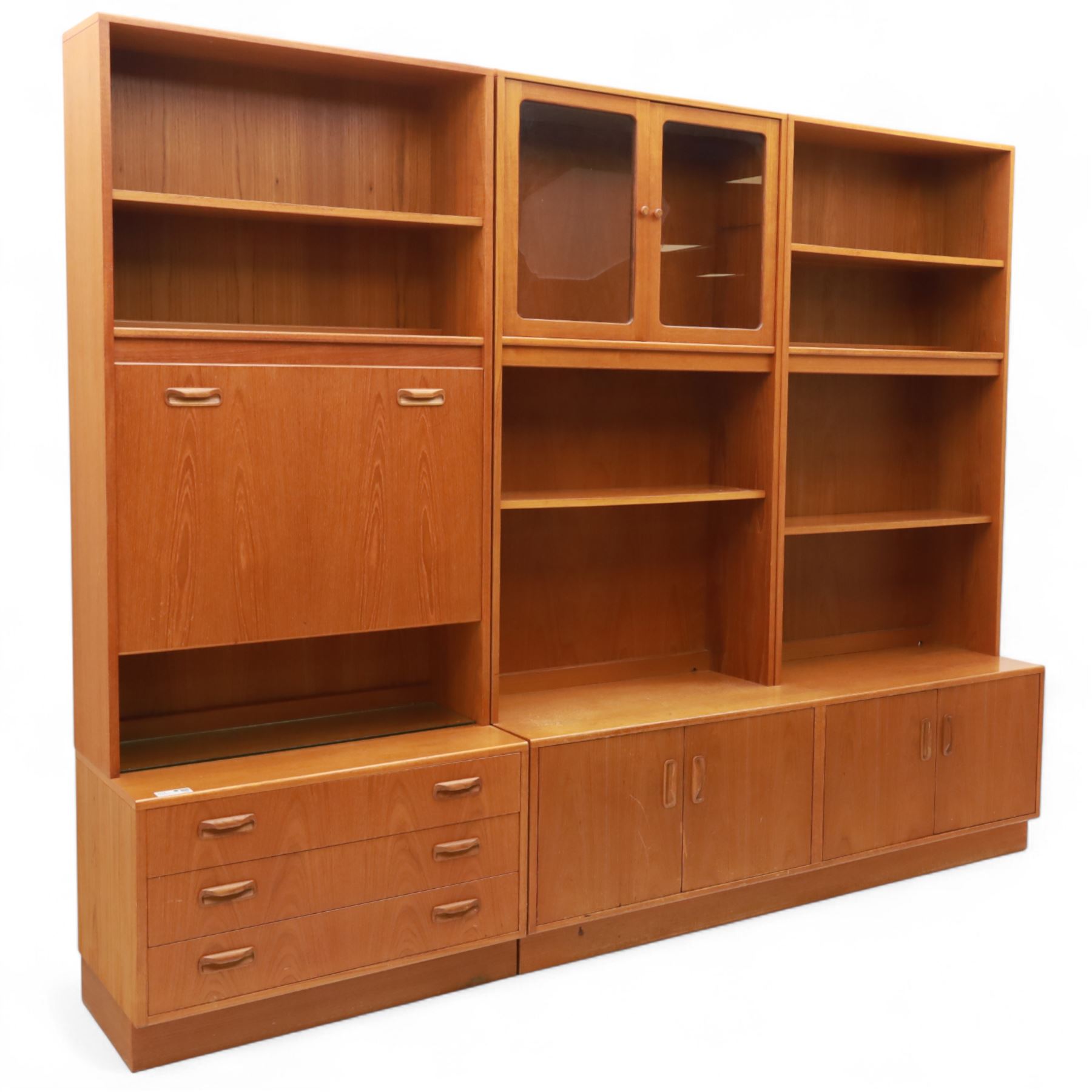 G Plan - Mid 20th century teak sectional wall cabinet, comprising six modular units including a fall front bureau, glazed display cabinet, open bookcase, cupboard and drawer bases, each with recessed handles and flush plinths