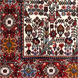 North west Persian Rudbar hand-knotted rug, ivory field woven with a repeating pattern of stylized shrubs, rosettes, and geometric floral motifs in tones of madder red, turquoise, indigo, and ochre, enclosed by a border of linked rosettes and angular flowerheads between narrow guard stripes 