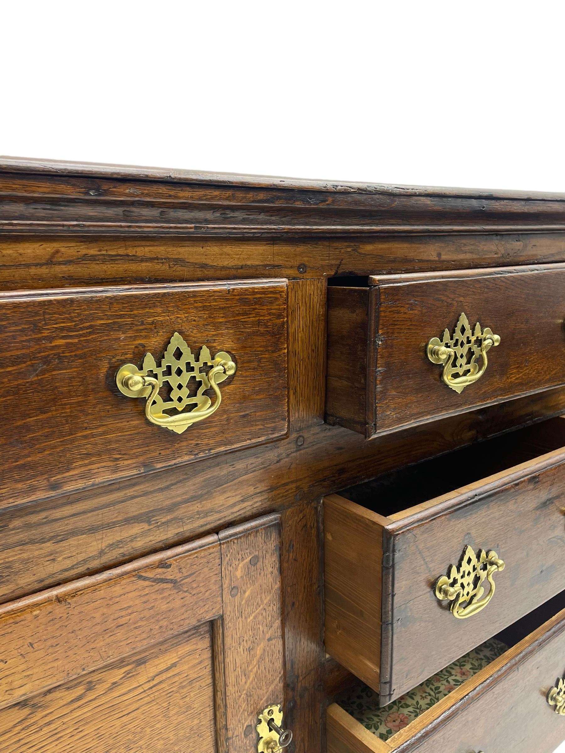 George III country oak dresser base,  rectangular top over with three central drawers flanked by two drawers and two panelled cupboards, each with moulded fronts, on stile feet