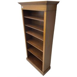 Edwardian inlaid mahogany open bookcase, projecting dentil cornice over crossbanded frieze, fitted with four adjustable shelves with reeded facias, on skirted base