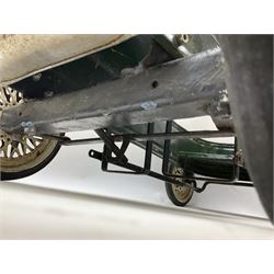 Mid 20th century pressed steel pedal car, the body painted in dark green fitted with pretend radiator to the bonnet, with spoked wheels and rubber tyres, the interior with pedals and steering wheel, L70cm