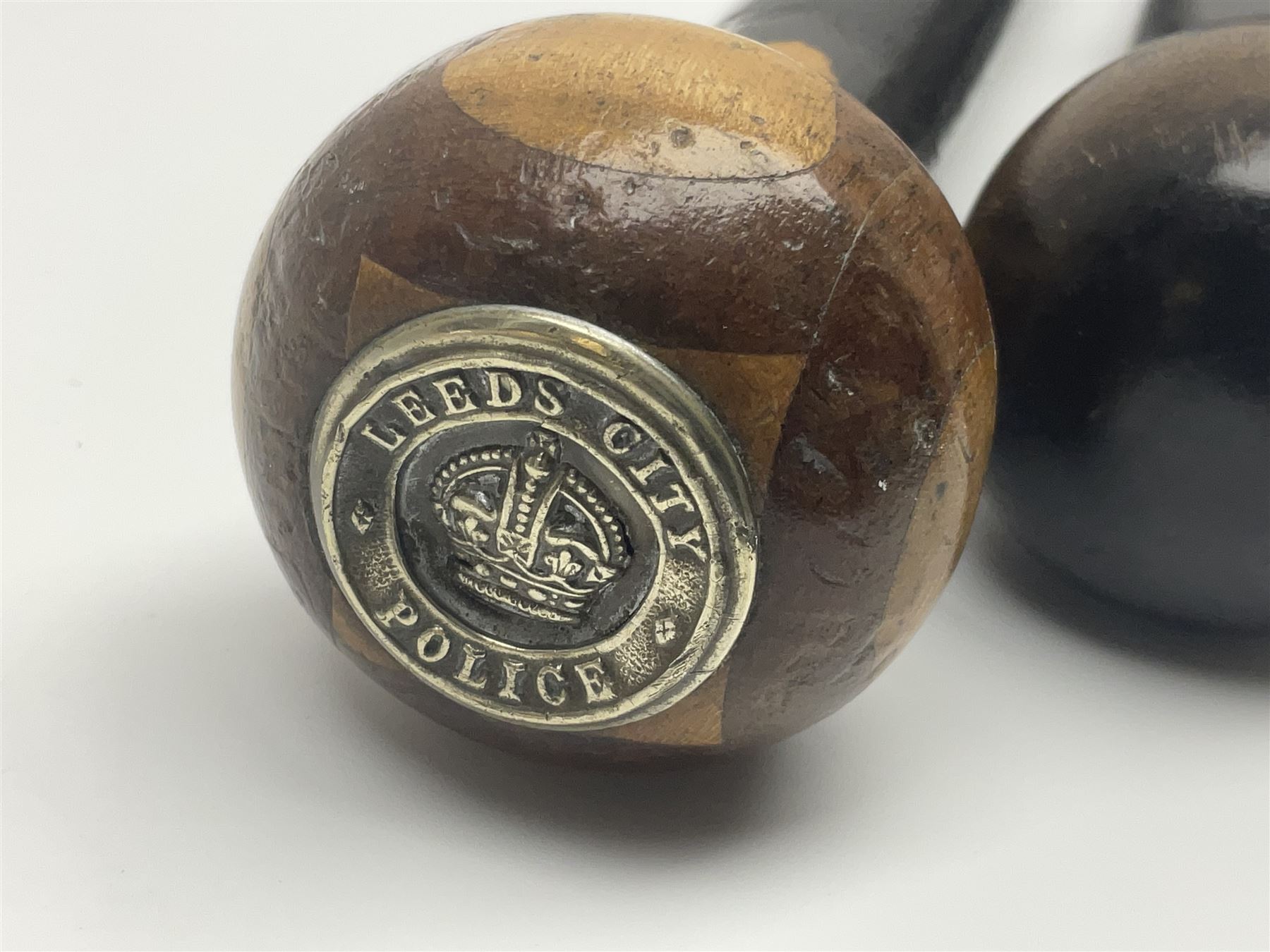 Two ebonised walking sticks, one with 'Leeds City Police' embossed top, tallest H92cm