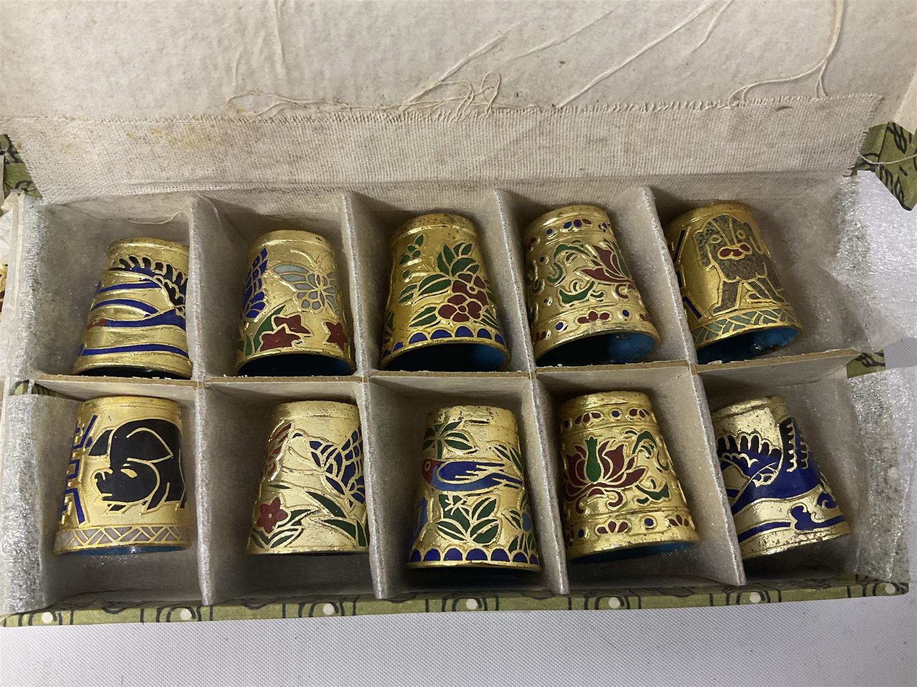 Twenty cloisonné thimbles, decorated with, flowers, birds, dragons