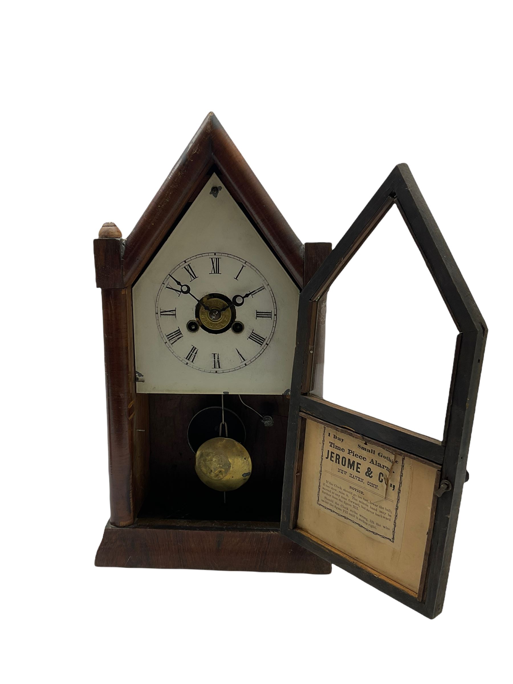 An American “Jerome” late 19th century  30-hour spring driven steeple clock with alarm, in a mahogany case with a decorative glass tablet depicting a rose painted white dial with roman numerals and minute track, steel moon hands and a brass alarm setting disc to the centre. With pendulum and key.
H40 W20 D10
With a small portable 19th century German “Wutternberg” alarm clock, the piece dial with a gilt centre and Ivorine chapter ring, Arabic hours and minute band, wooden case with brass fittings and carrying handle on four feet, wound and set from the rear with integral keys, alarm sounding on a bell. 
H20 W12 D7
