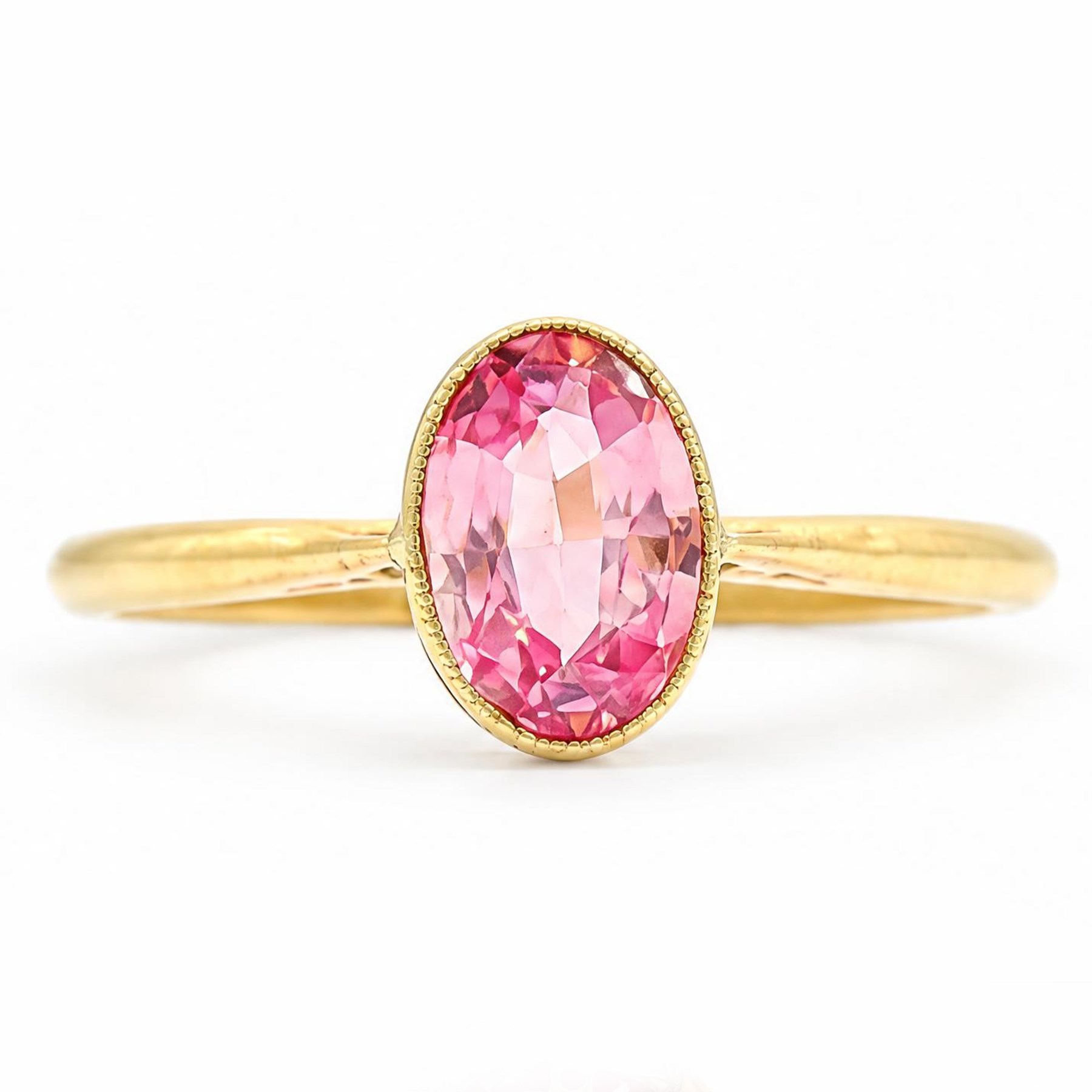 Early 20th century gold padparadscha sapphire ring, milgrain set with a single oval cut sapphire of approx 1.05 carat