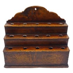 George III boarded oak spoon rack, with shaped pediment over three stepped tiers, each with five apertures, H34cm L38cm D17cm