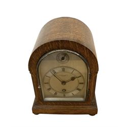 German- early 20th century oak cased 8-day mantle clock, with a round top, side frets and conforming glazed door to the dial, single sheet silvered dial with a silvered chapter and fast/slow regulation dial, Roman numerals, minute track and spade hands, going barrel movement with a lever platform escapement. With Key. 