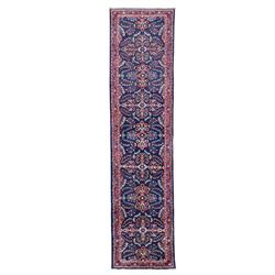 North West Persian runner, the indigo field decorated with repeating symmetrical floral sp...