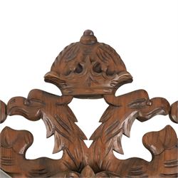 Carved wooden wall plaque, decorated with foliate scrolls, with two reproduction swords attached, together with five other wooden plaques with foliate scrolls and shields