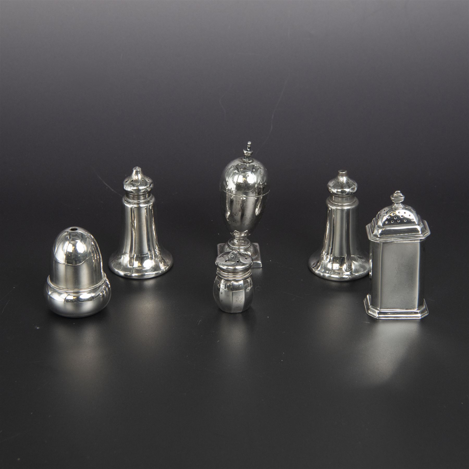 Group of silver cruets, including a pair of Edwardian conical shaped salt and pepper shakers and four other salt/pepper shakers, all hallmarked 