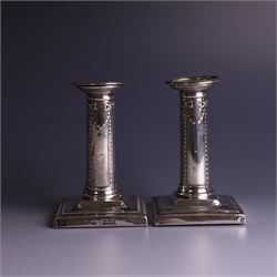 Pair of late Victorian silver mounted candlesticks, the stems embossed with classical ribb...