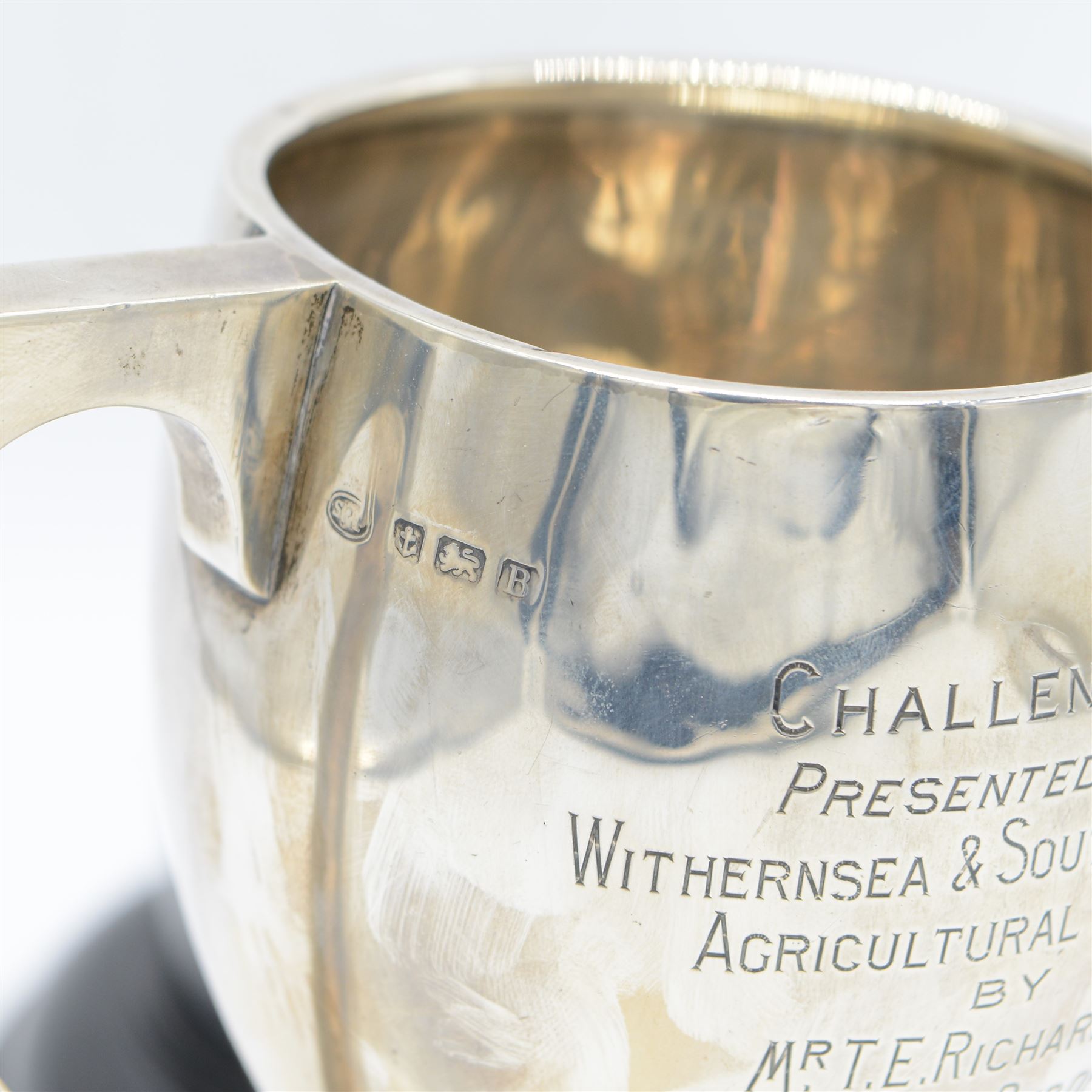 1920s silver twin handled trophy with engraving to body, upon circular foot and ebonised wooden plinth, total height H20cm