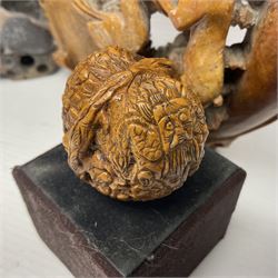 Carved soapstone puzzle ball, together with carved walnut shell and three soapstone brush pots, ball D12cm