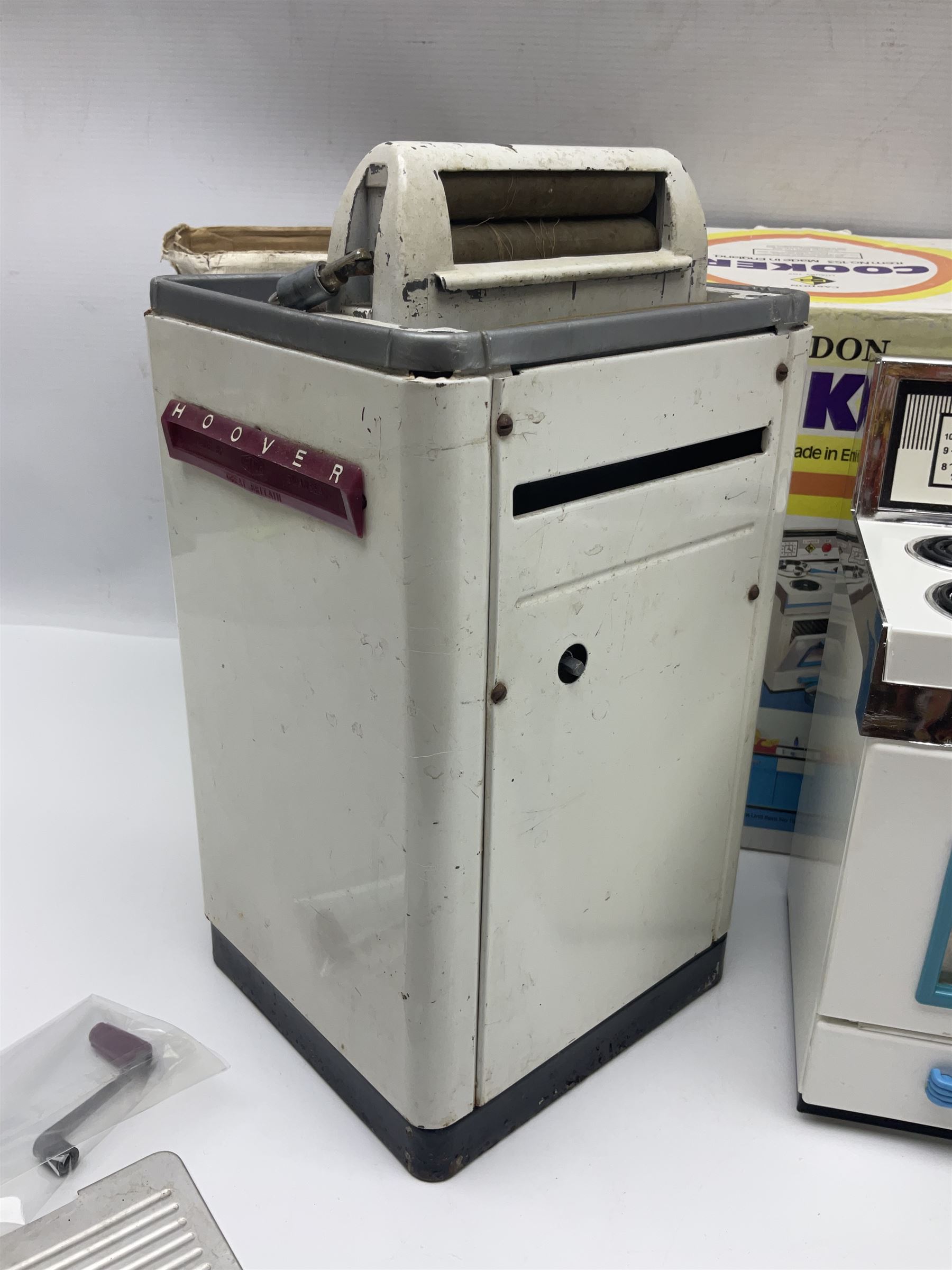 Six toy kitchen appliances - Casdon battery operated cooker; Mettoy Hoover washer; Chad Valley Hoovermatic washer; Wells Brimtoy tin-plate clockwork washer; and two Morphy Richards irons; together with a continental child's Regina sewing machine; all boxed (7)