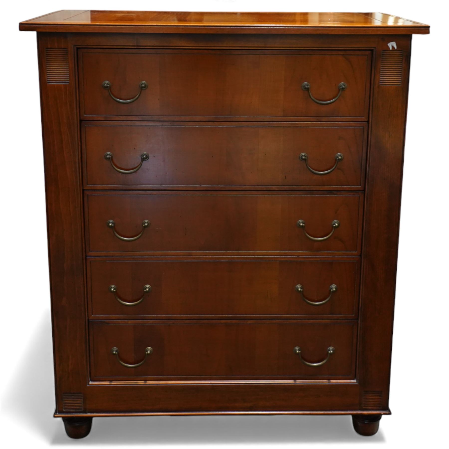 French cherry wood chest of drawers, rectangular moulded top above five long drawers with brass swing handles, flanked by reeded corner panels, raised on turned bun feet