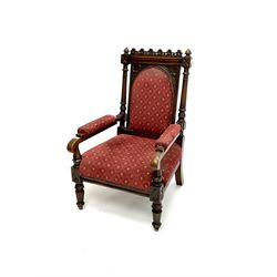 Victorian carved oak open armchair, shaped cresting rail, tapering supports, upholstered in red patterned fabric 