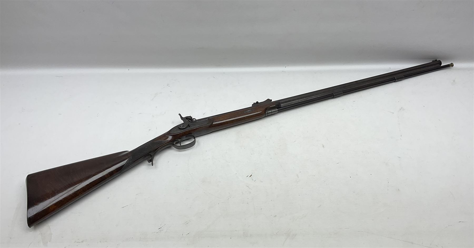 Mid-19th century percussion rifle by Geo. Forrest & Sons of Jedburgh No.844, 79cm octagonal barrel (approx .45 bore) with folding foresight, the lock plate with dolphin hammer finely engraved with a tiger and a stag, trigger guard engraved with hounds chasing a stag, figured walnut half stock with chequered grip and original ramrod 121cm overall; with framed photograph of original owner Dr. A.B. Dresser and archive of related ephemera including manuscript letter from the makers to Dr. Dresser regarding the sight specifications.