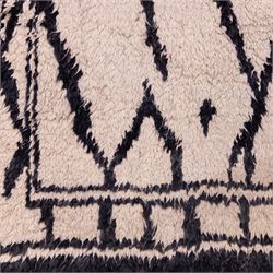 Moroccan Berber wool hand knotted rug, the cream ground decorated with abstract diamond forms and angular lines in dark brown, enclosed by a simple patterned border, with short fringe ends