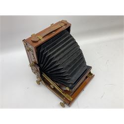 Ensign 'The Sanderson' folding plate camera in mahogany and lacquered brass, field model with canvas wrapped box, two mahogany photographic plates, 'Busch rapid Symmetrical F:8' lens,  and a wooden tripod 