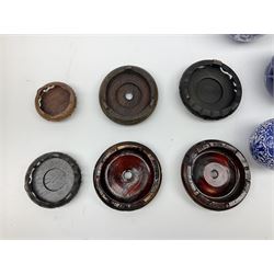 Six Chinese ginger jars, predominantly of blue and white design decorated with blossoming branches, all with lids, housed on various hardwood carved stands, some with character marks beneath