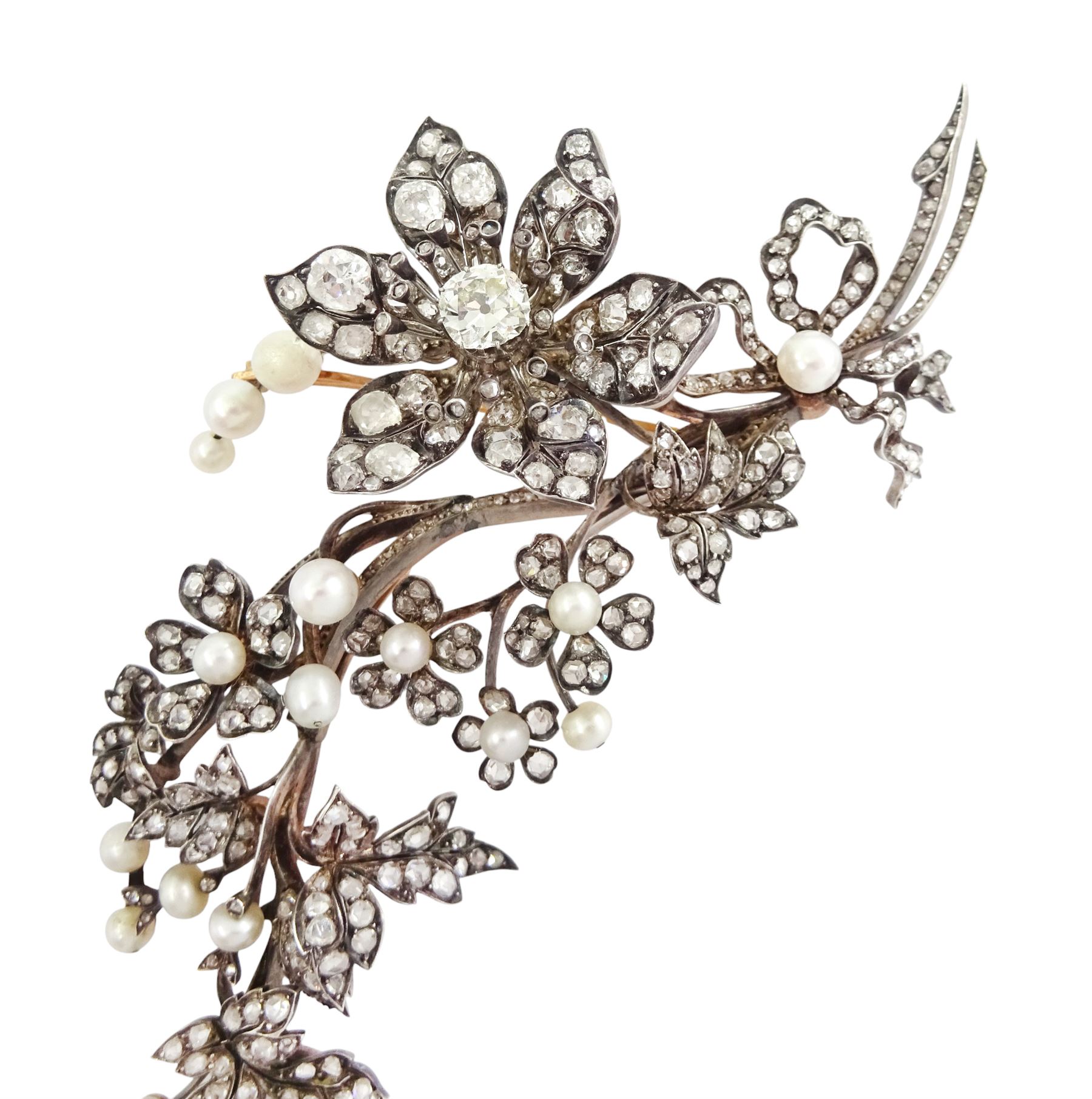 19th century gold and silver diamond and pearl en tremblant detachable brooch, the flower tremblant with a principal old cut diamond of approx 1.90 carat, the petals and stamen set with old cut and rose cut diamonds, total diamond weight approx 9.10 carat, to a foliate spray set set with further rose cut diamond and white / pink / cream pearls and ribbon tie
