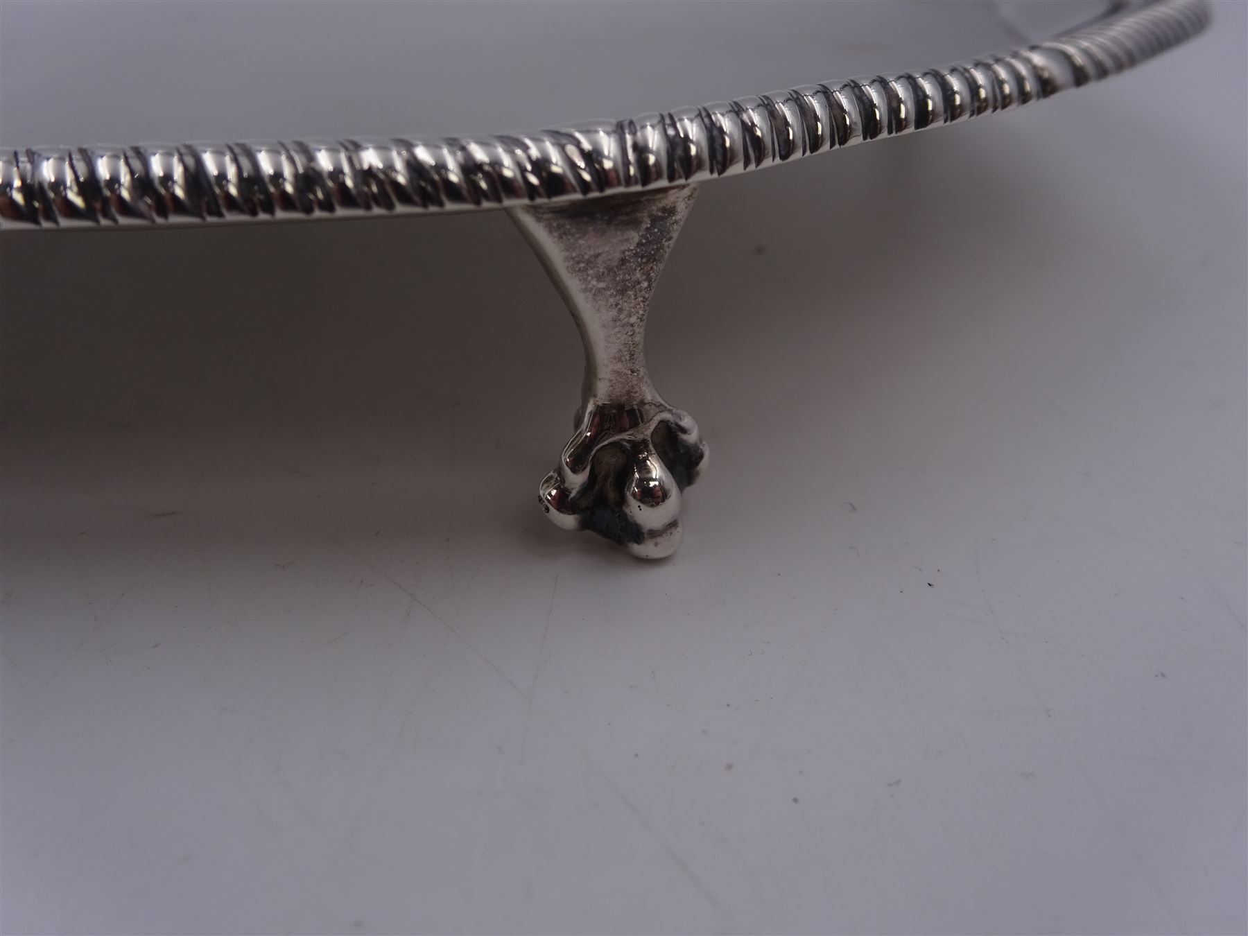 Early 20th century silver waiter, of hexagonal form, with oblique gadrooned rim, upon four ball and claw feet, hallmarked Goldsmiths & Silversmiths Co Ltd, London 1919, D21cm