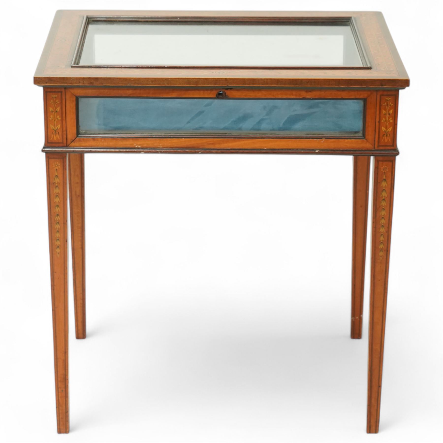 Edwardian satinwood bijouterie table, rectangular glazed top and glazed sides enclosing a blue velvet-lined display well, raised on square tapering legs, decorated throughout with neoclassical foliate inlay