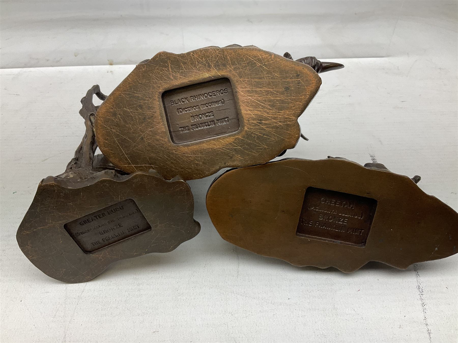 Six Franklin Mint bronze models of African animals, comprising Lion, Black Rhinoceros, Greater Kudu, Cheetah, Giraffe and African Elephant, tallest example H14cm