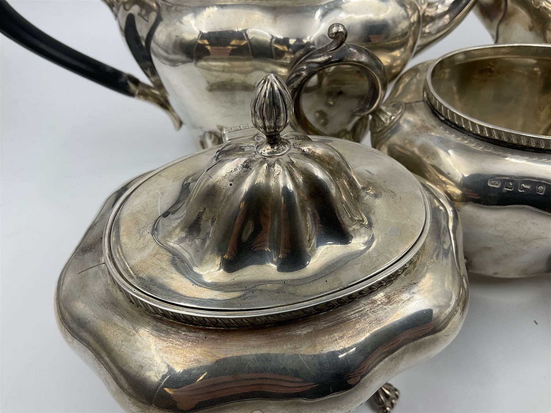 Five piece Edwardian silver tea service, comprising teapot and coffee pot, each with ebonised scroll handle, tea caddy with hinged cover, twin handled open sucrier, and milk jug, each of rounded bombe form, upon four paw feet, hallmarked William Adams Ltd, Birmingham 1904 and 1905, coffee pot H26cm

