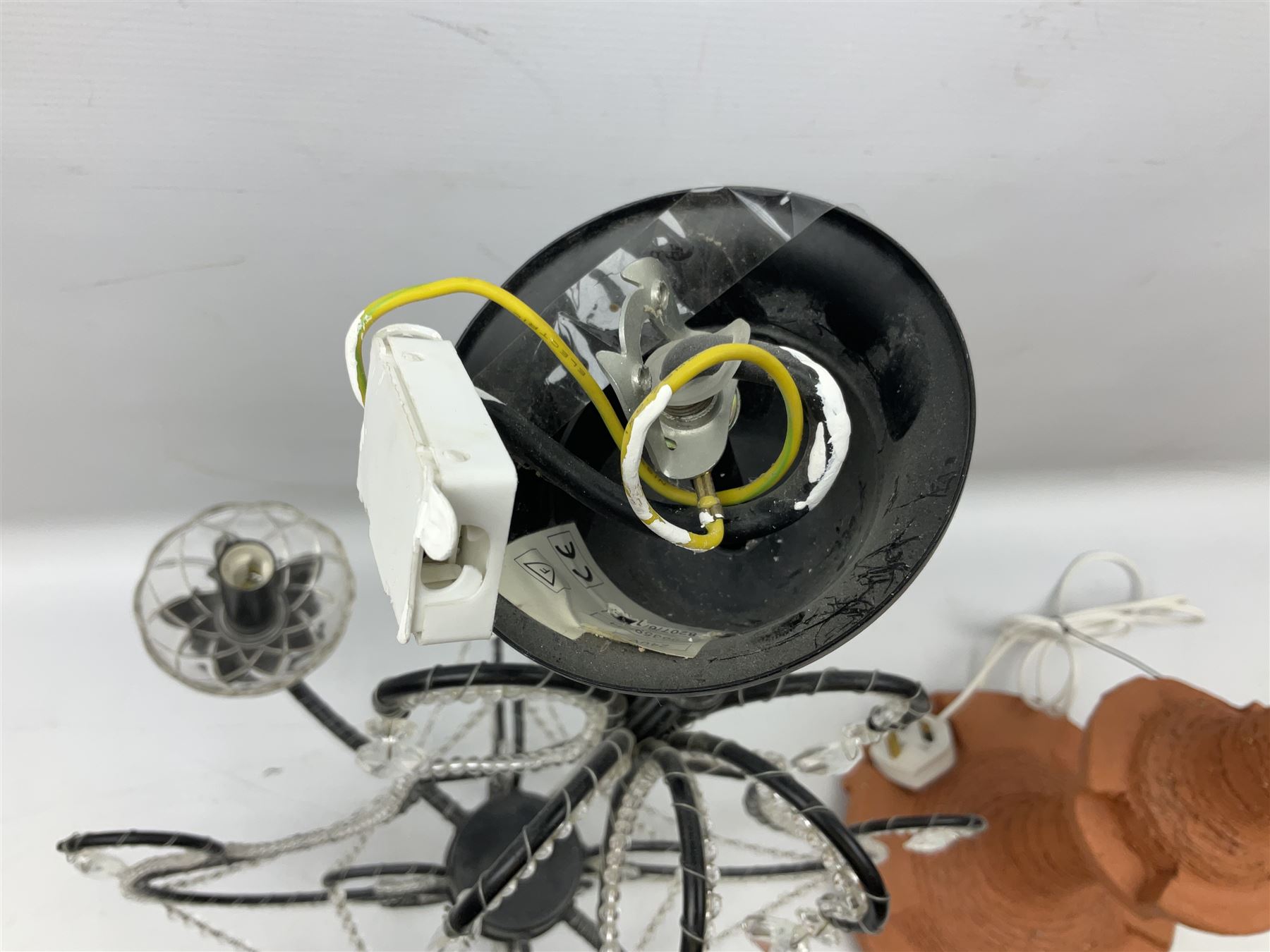 Terracotta studio pottery lamp base with carved detail and geometric knop and base, H45cm, together with a black chandelier with drops, Mid century teak light fitting with three drop down clear glass pendants and copper mounts, H54cm, and Rhinestone and black eight branched chandelier