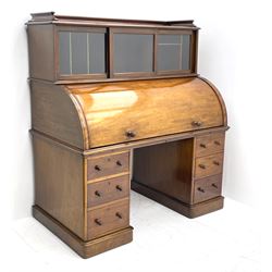 Victorian mahogany cylinder roll top secretaire desk, raised document compartments enclosed by three sliding glazed doors, the roll top revealing sliding sloped writing surface with hinged lid, pigeon and letter holes, the twin pedestals fitted with three drawers, plinth base
