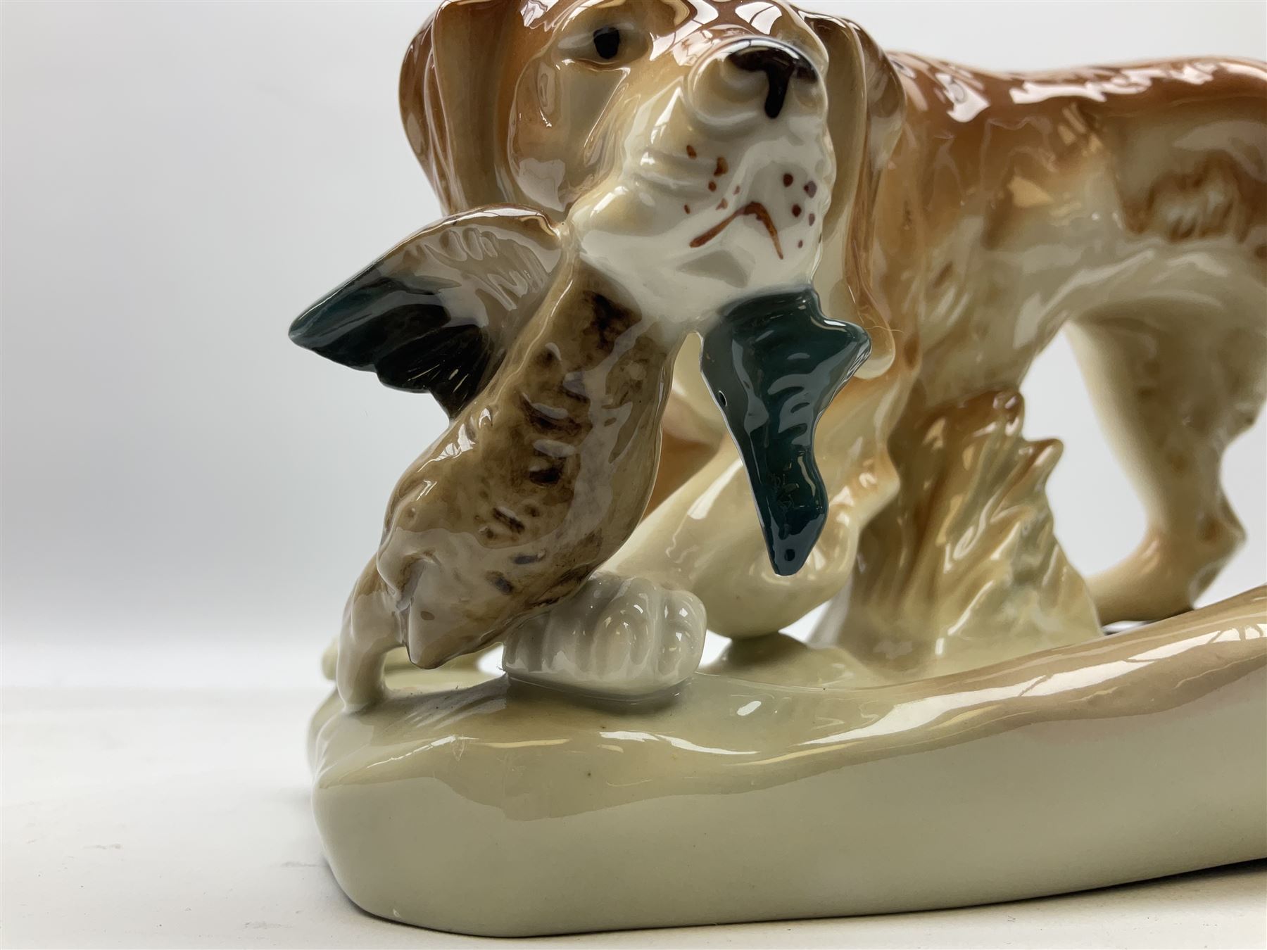 Royal Dux porcelain hunting dog with a bird, printed mark beneath, L36cm