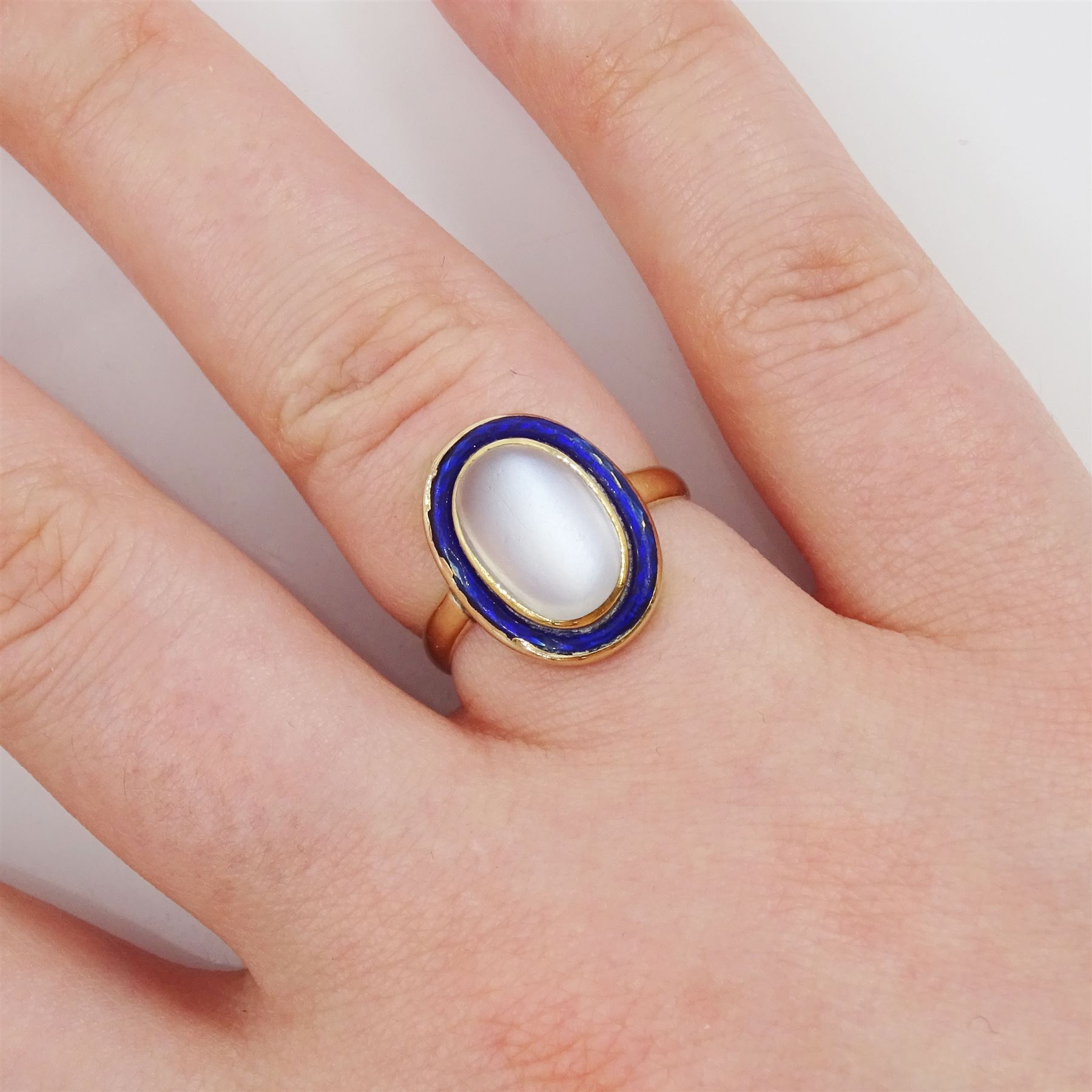 Early 20th century moonstone and blue enamel ring, stamped 9ct
