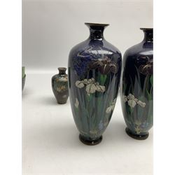 Pair of Japanese Meiji period cloisonné vases of slender ovoid form decorated with iris flowers in purple and white on deep blue ground,  together with four cloisonné bowls decorated with dragons and flowers with enamelled blue interiors, and further miniature vase, tallest H20cm