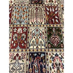 Persian Heriz design rug, ivory ground with rectangular panels each depicting garden scenes of tree of life, plants and Boteh motifs, the guarded border decorated with wildlife and bird scenes