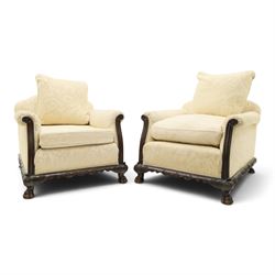Quality Edwardian carved mahogany lounge suite comprising three-seater settee and pair of armchairs, the sofa with arched back over rolled arms and deep sprung seat, the arm terminals carved with acanthus rosette over gadroon and rope-twist moulding, the shaped apron carved and moulded with scrolling foliate acanthus motifs, terminating to four large front hairy paw and ball feet, upholstered in pale yellow foliate fabric with matching seat and scatter cushions (W200cm D105cm H73cm); the matching deep armchairs (W78cm D95cm H75cm)