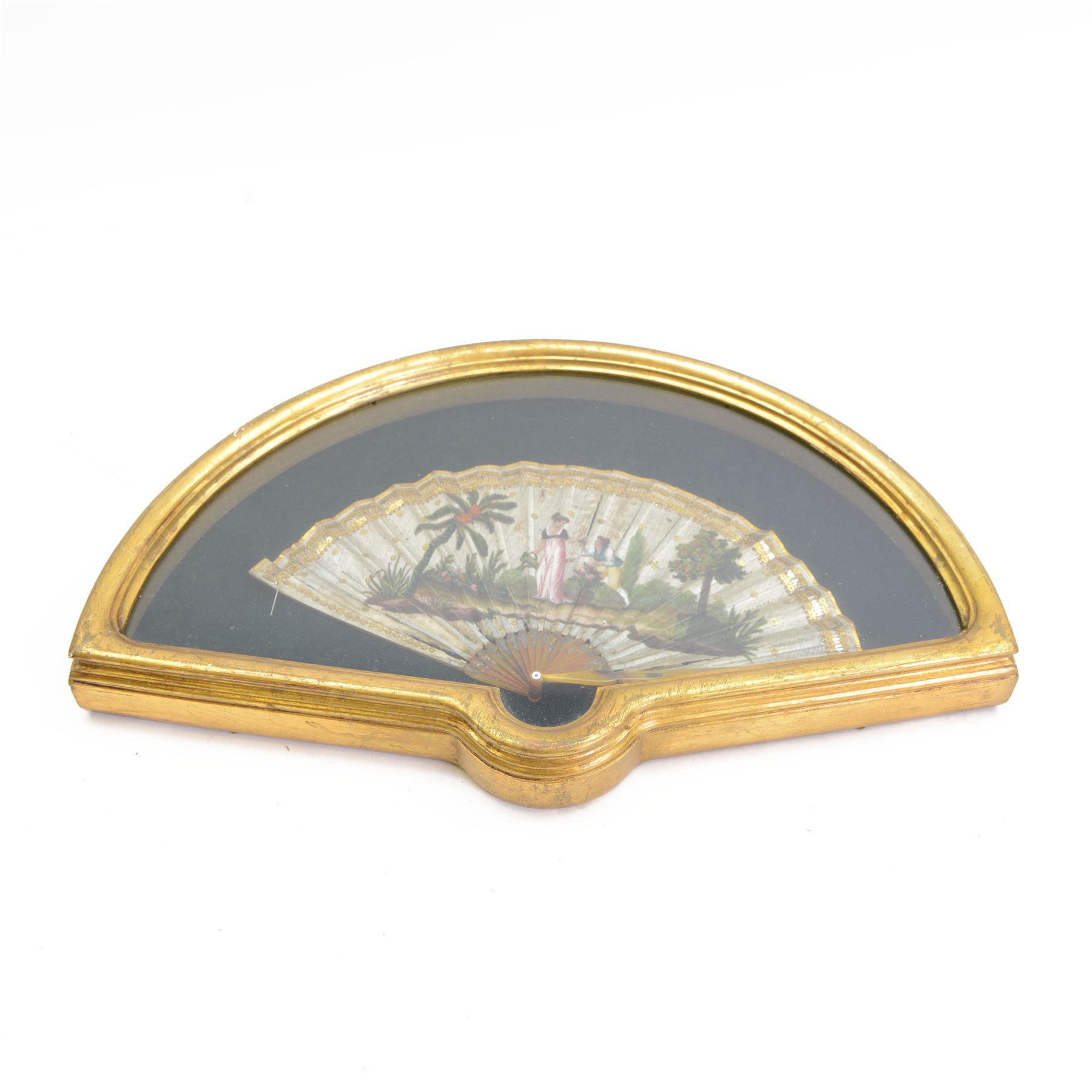 18th century fan, the horn sticks and guard with silvered and gilded decoration, the silk leaf painted in strong colours with a young couple in a garden setting, within a border of gold coloured sequins, framed and glazed, overall H35cm L55cm
Provenance: From the Estate of the late Dowager Lady St Oswald