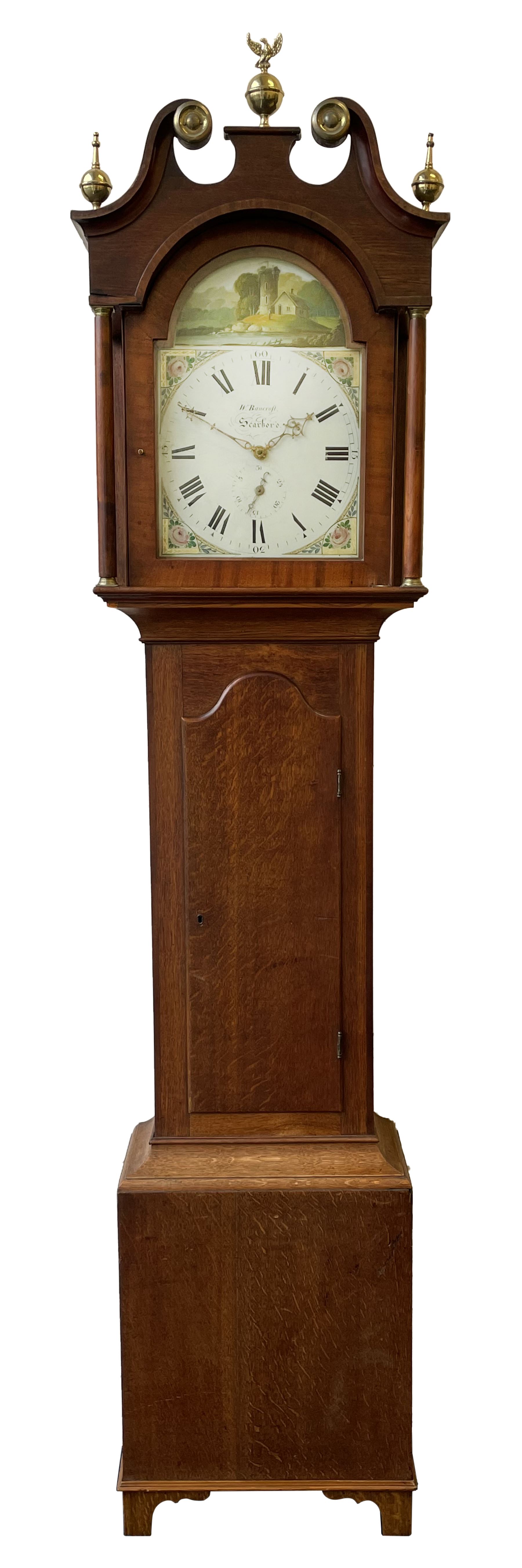 Thirty-hour oak cased longcase clock by  William Bancroft of Scarborough circa 1830, with a swan’s neck pediment, brass patera and three brass spire and ball finials, stepped break arch hood door flanked by plain pillars with brass capitals, trunk with a full length door and curved arch top, on a plain square plinth with bracket feet, painted break arch dial with roman numerals and quarter hour Arabic’s, date recorder (anti clockwise) and matching brass hands, arch painted with a rural scene depicting a ruined tower and cottage with depictions of flowers to the spandrels, dial pinned directly to a chain driven countwheel striking movement, striking the hours on a bell. With weight and pendulum. The Bancroft family were prodigious Scarborough clockmakers during the 18th and 19th century, William Bancroft is recorded as working in Newborough Street from 1820 onwards. 


