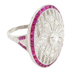 Platinum diamond and ruby oval cluster ring, principal transitional cut diamond of approx 0.55 carat, with milgrain set openwork diamond surround and calibre cut ruby border, with ruby and diamond shoulders