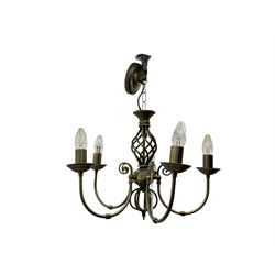 Pair of brass five-branch chandeliers, each featuring scrolling arms with candle-style light fittings, centred by a twisted openwork column, complete with ceiling roses and hanging chains